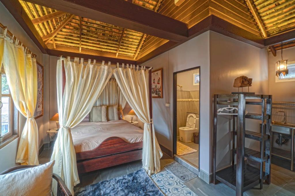 una camera con letto a baldacchino e un bagno di PP Place cnx 2 a Chiang Mai