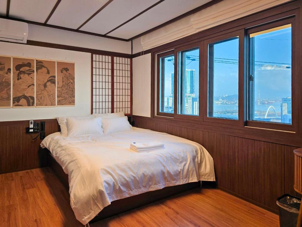 - une chambre avec un grand lit et des fenêtres dans l'établissement Staykor Busan, à Pusan