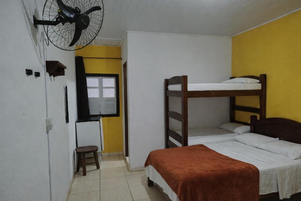 Giường trong phòng chung tại Suíte Tropicália