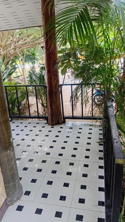 a balcony with a palm tree and a view of the beach at Turtle beach Bar 1 Bedroom in Thai Muang