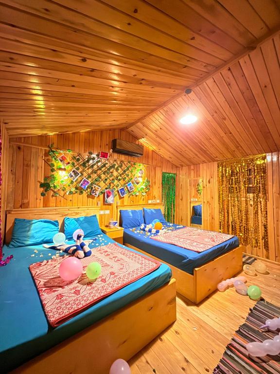 due letti in una stanza con pareti in legno di Relax Beach Camp a Nuweiba‘ el Muzeinah