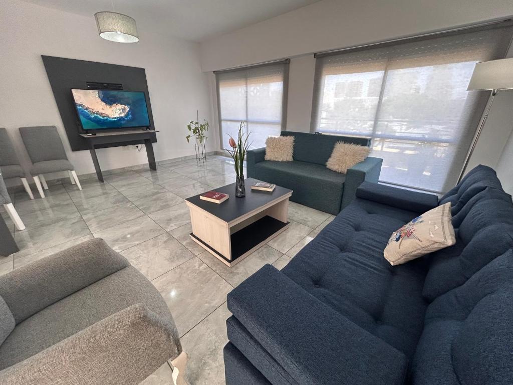 a living room with a blue couch and a tv at Apart Luro I in Santa Rosa