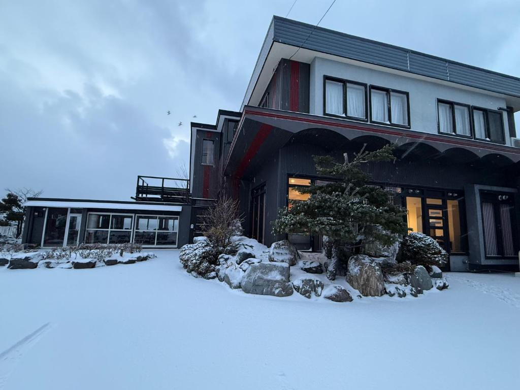 een huis met sneeuw ervoor bij Moonbay Beach Villa in Lake Toya