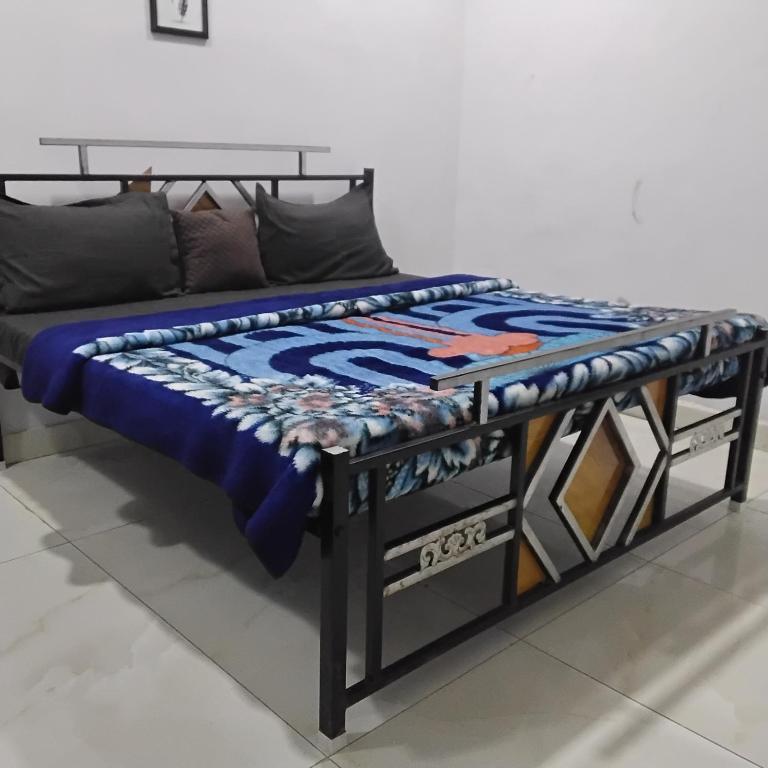 a bed with a blue blanket on top of it at nyagaon swimming pool in Malaut