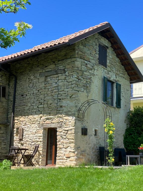 an old stone house with a grassy yard at Casavabene Appartamenti - for hikers, bikers and slow travelers in Murazzano