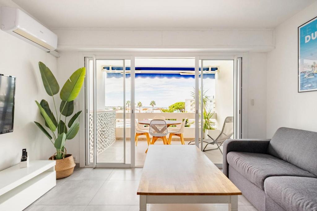 a living room with a couch and a table at Le Plein Sud in Le Grau-du-Roi