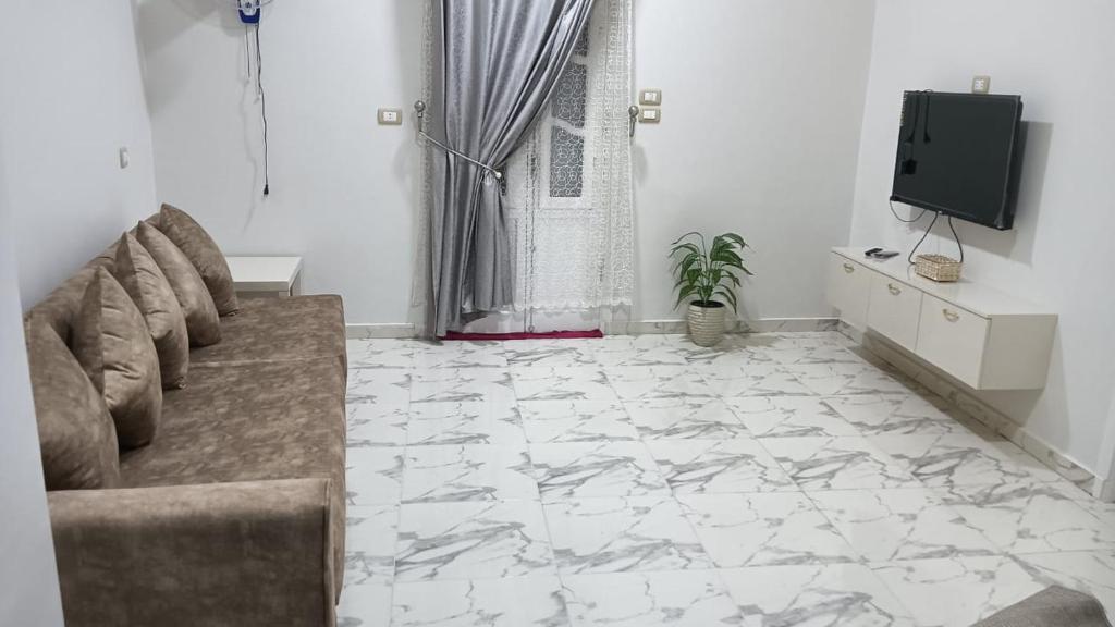 a living room with a couch and a tv at noreno houseاسوان شياخة تانية طريق السادات in Aswan