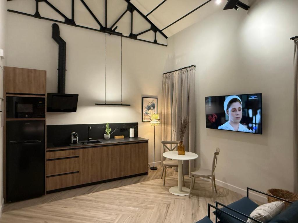 ein Wohnzimmer mit einer Küche und einem TV an der Wand in der Unterkunft Arcos de Santa Marta in Córdoba