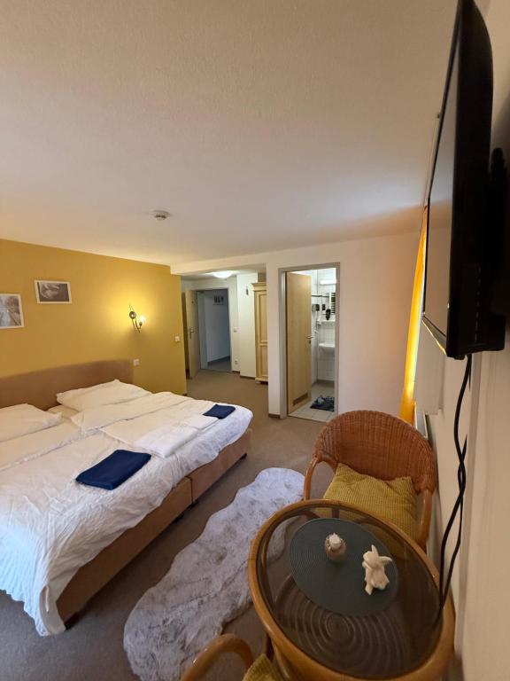 een slaapkamer met een bed, een tafel en een televisie bij Leos und Armando Gjuci GbR in Großpostwitz