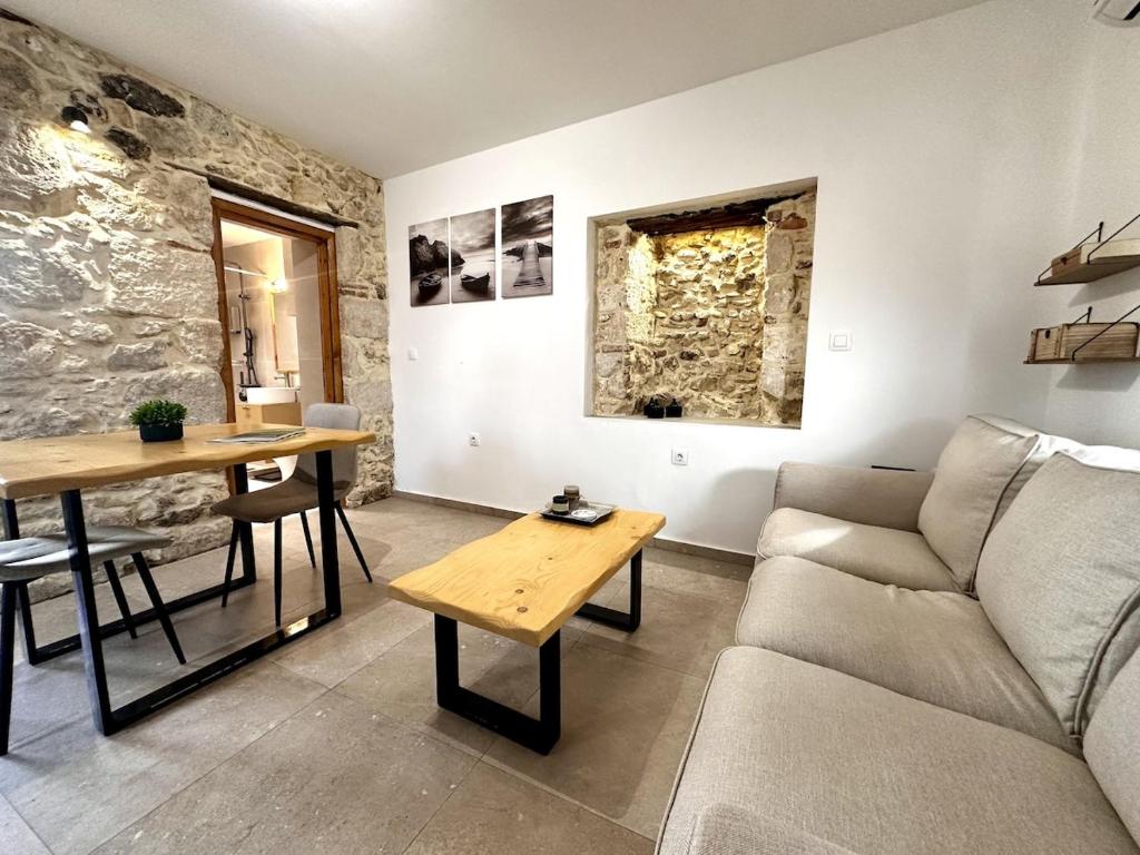 un soggiorno con un divano e un tavolo di Nomas Home Kalyves a Kalyves