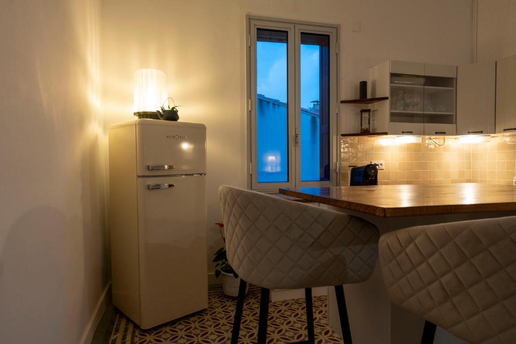 una cucina con frigorifero e bancone con bar di Chez Jojo a Port-Vendres