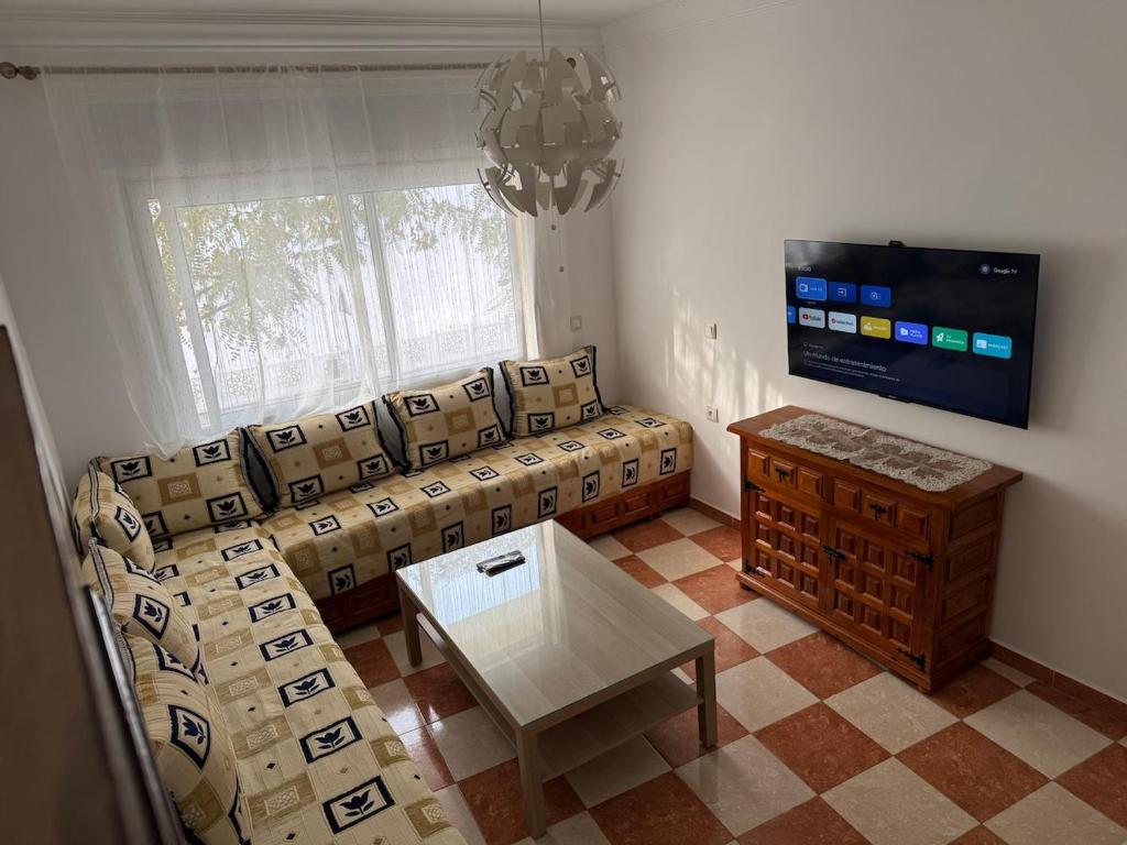 ein Wohnzimmer mit Sofa und Fernseher in der Unterkunft My home in Tétouan