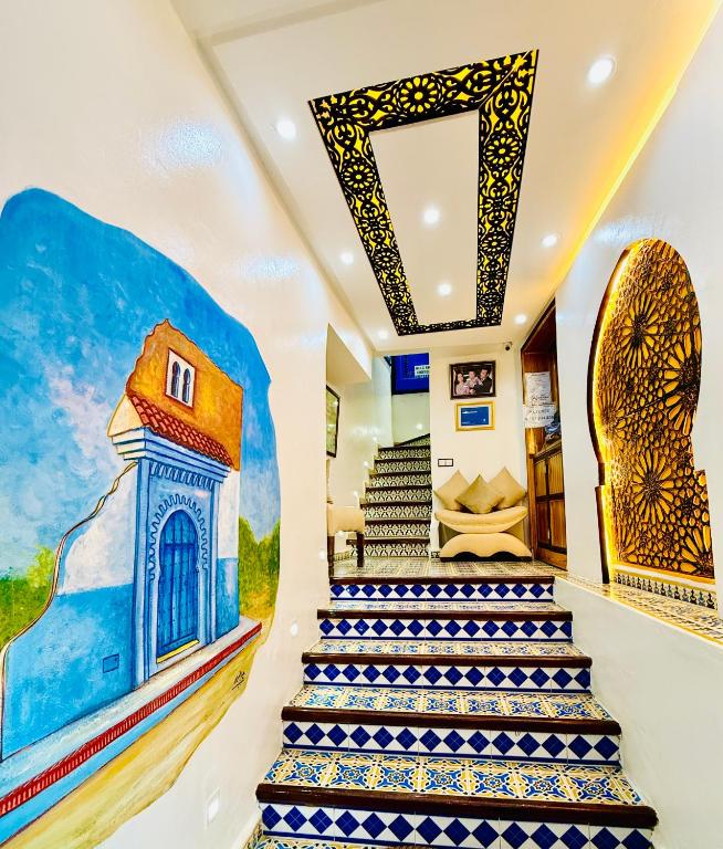 a staircase with a painting on the wall at Hôtel Koutoubia in Chefchaouen