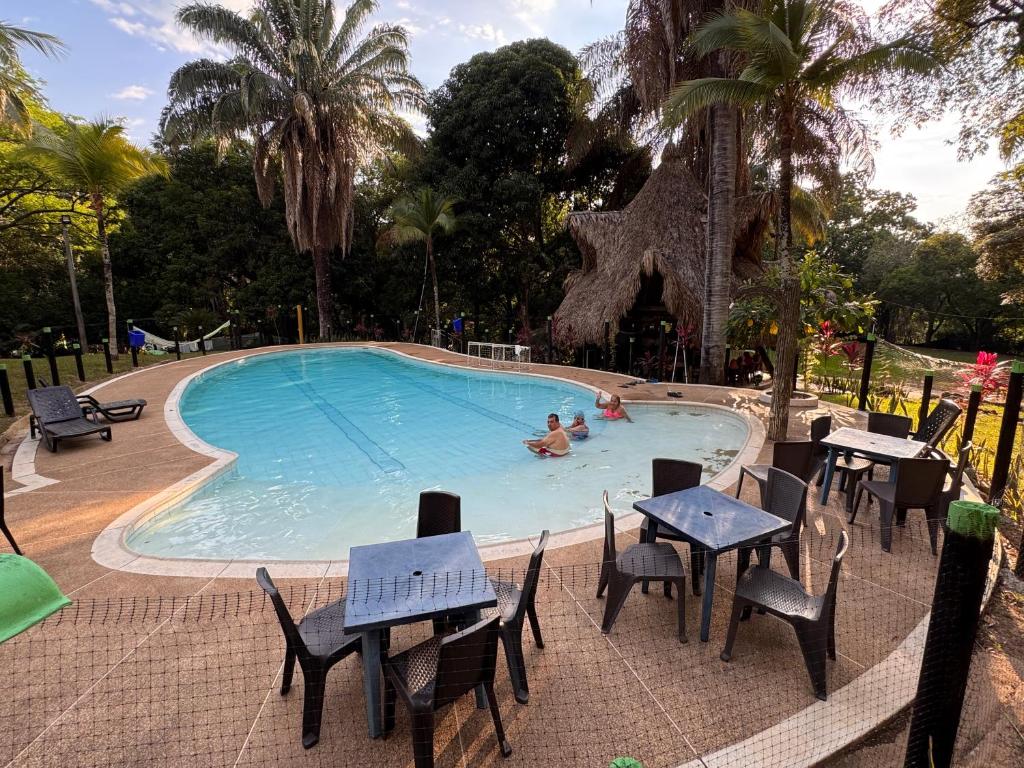a pool with tables and chairs and people in it at Eco Hotel El Reposo Melgar in Melgar