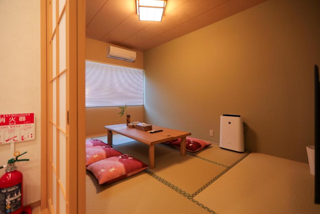 a room with a table and a bench in a room at 朱鷺ノ清101 in Odawara