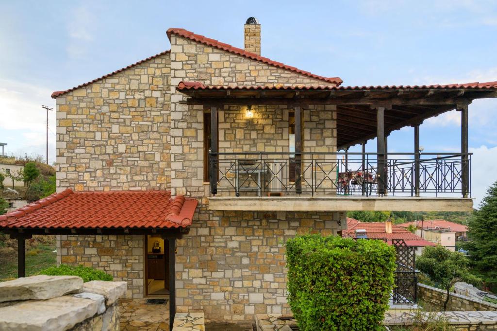 una casa in pietra con balcone e veranda di Villa-Τo Petrino a Krionérion