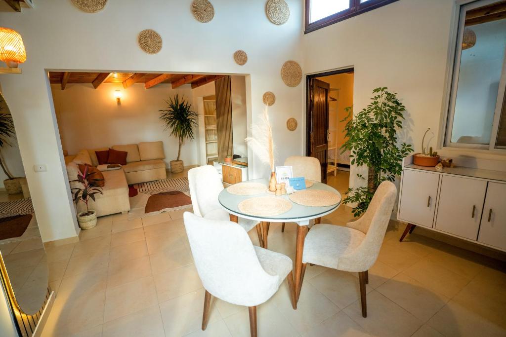 a living room with a table and white chairs at Umbi Chalet in Dahab