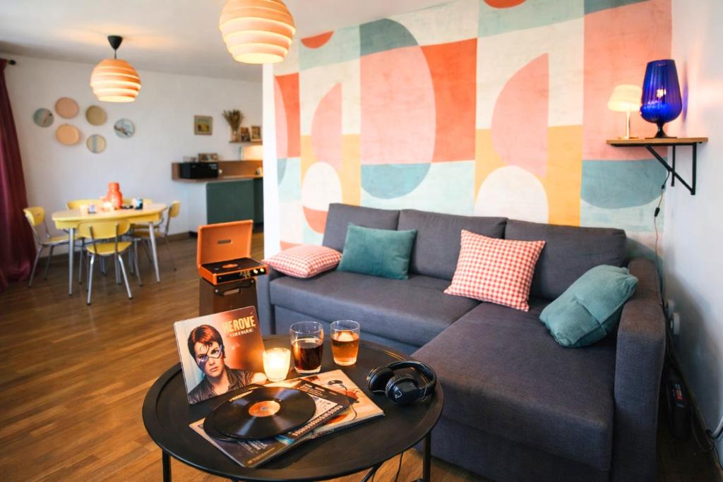 ein Wohnzimmer mit Sofa und Tisch in der Unterkunft Vinyle club-rétro 70's-6 pers-Terrasse-Wifi-Parking in Bellême