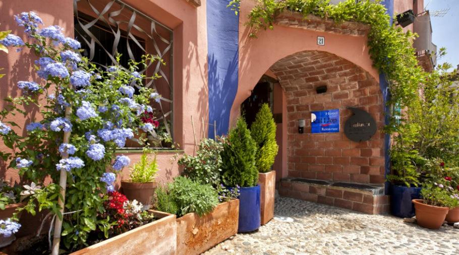 un bouquet de fleurs dans des pots à l'extérieur d'un bâtiment dans l'établissement Hotel Cal Llop, à Gratallops