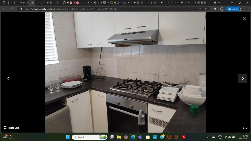 een keuken met een fornuis en een fornuis bovenste oven bij KINGSLEY Green in Gqeberha