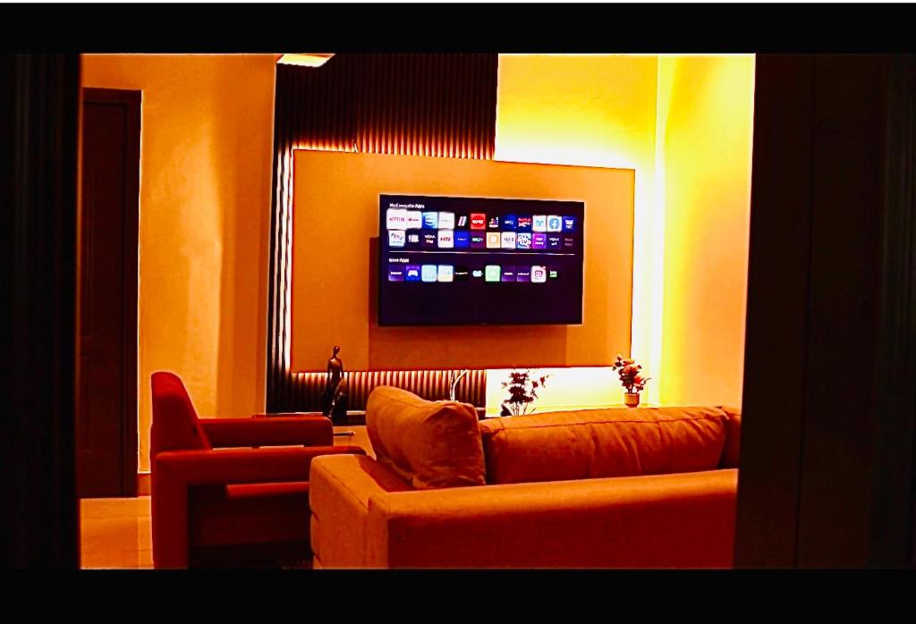 ein Wohnzimmer mit Sofa und Flachbildfernseher in der Unterkunft Ghanas Finest The Reach in East Legon