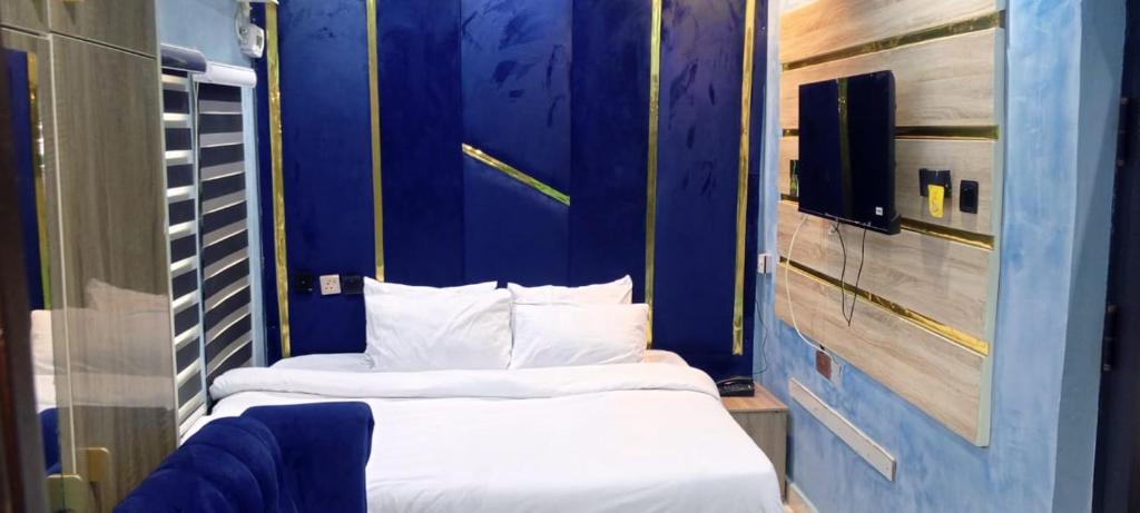 two beds in a small room with blue walls at 517 VIP suites and apartments in Awka