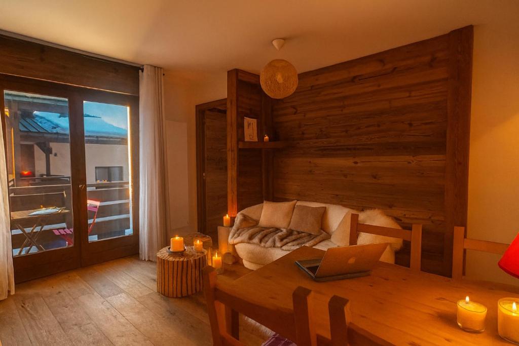 un soggiorno con un tavolo e un divano di Melba Megeve emplacement de rêve dans le village au calme a Megève