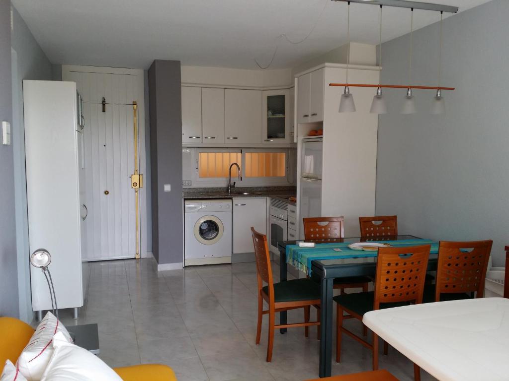 a kitchen and dining room with a table and chairs at Family Sun Seasight Apartment in Cala Millor