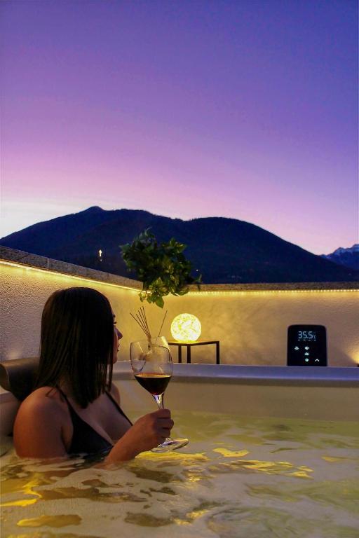 a woman sitting in the water with a glass of wine at Terrazza Domese in Domodossola