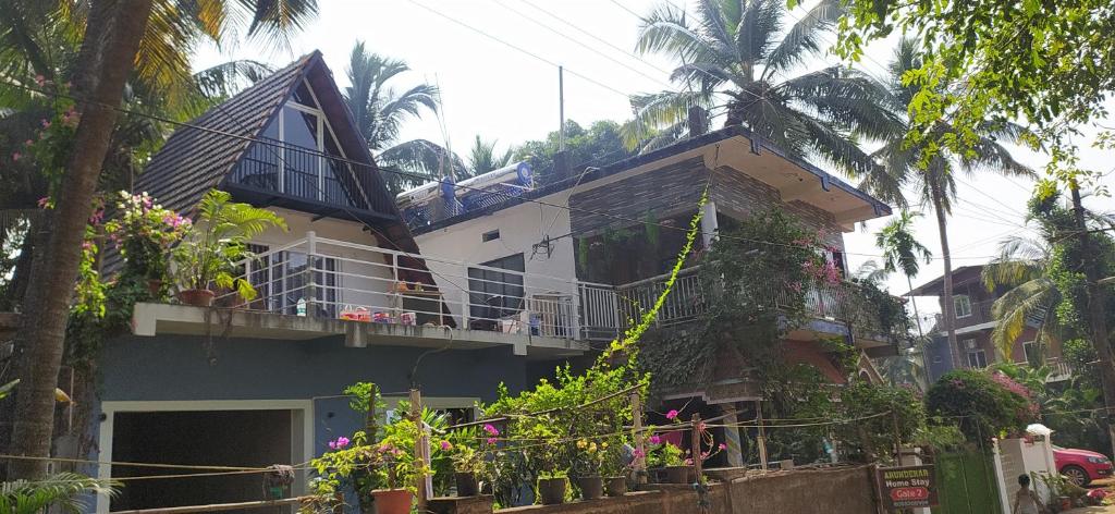 a house with a balcony with flowers on it at Sarvesh Arundekar Home Stay In Beach Side AC Room in Gokarna