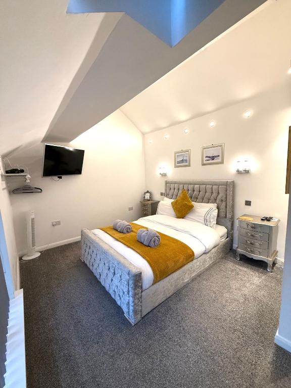 a bedroom with a bed and a tv on the wall at Luxury Apartment in Blackpool