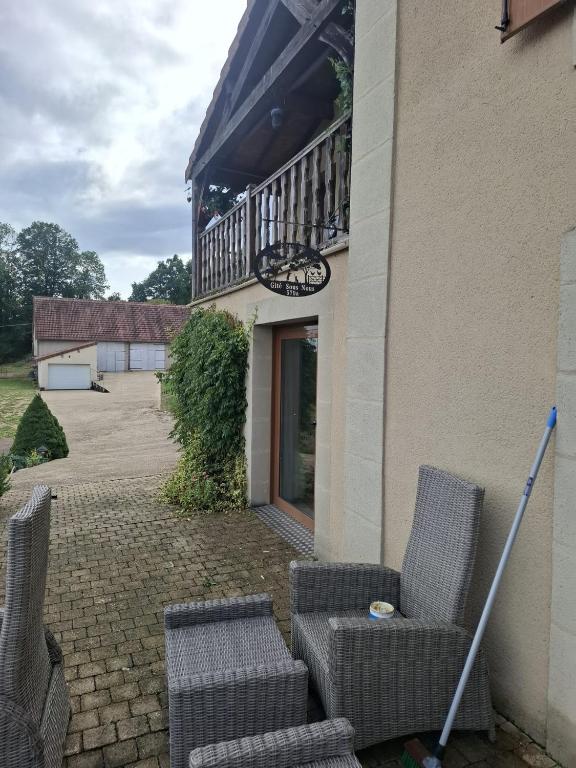 a patio with two chairs and a balcony at Gîte Sous Nous in Youx