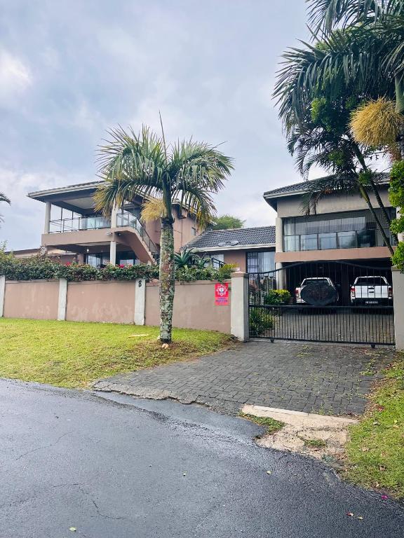 a house with a palm tree in front of it at Sanlou - Southport in Port Shepstone