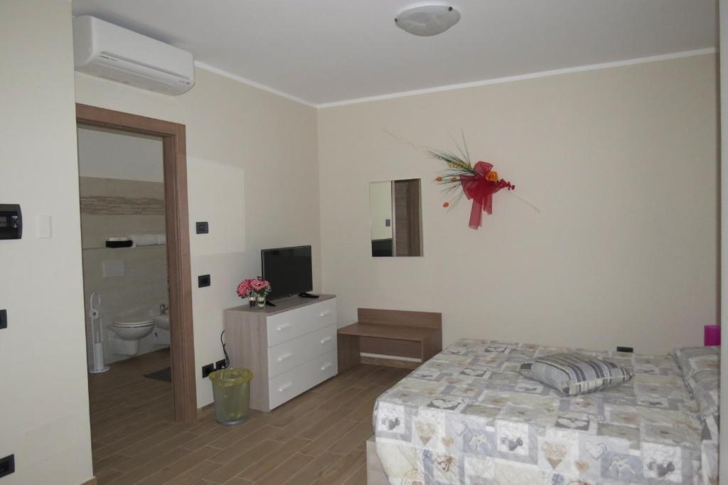ein weißes Schlafzimmer mit einem Bett und einem Badezimmer in der Unterkunft Cristallo Camere in Alba