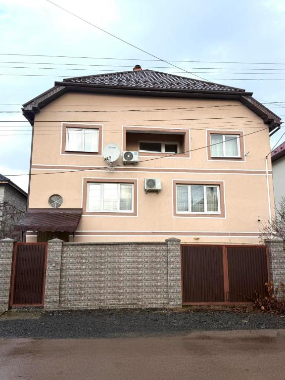 a large pink house with a fence in front of it at Будинок в Мукачево in Mukacheve