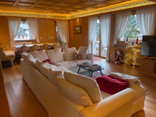 a living room with a large couch and a table at Chalet Luxury Pelmo in San Vito di Cadore