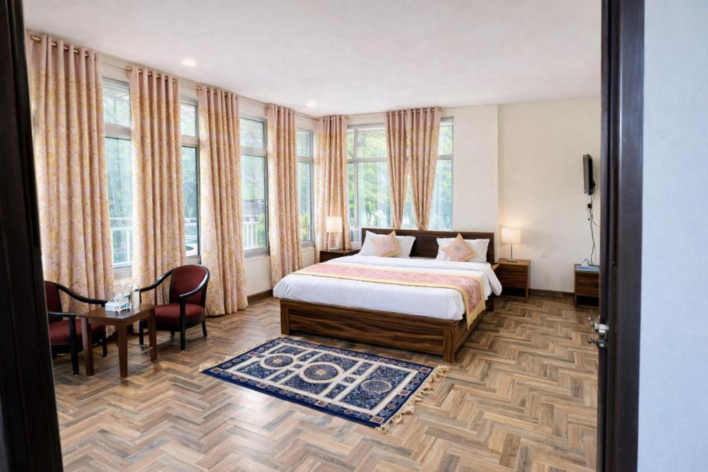 una camera da letto con un letto, un tavolo e delle sedie di Hotel Madhushree Morning Moon In - Restaurant & Free Parking Facilities - Best Premium Hotel In Bhimtal a Bhimtal