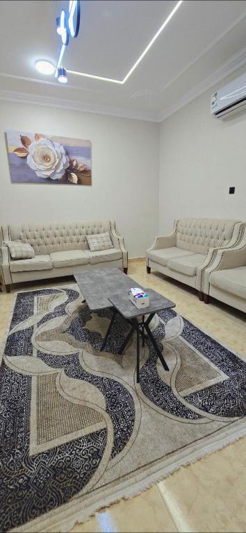 a living room with a couch and a table at شقق النزهة الفندقيه in Riyadh Al Khabra