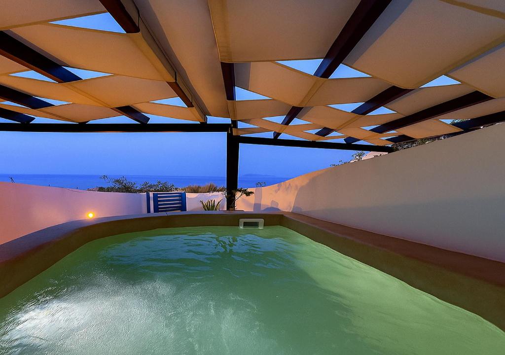 einen Innenpool mit Dach in der Unterkunft Rafael' s Mediteranian Cave Suites in Firostefani