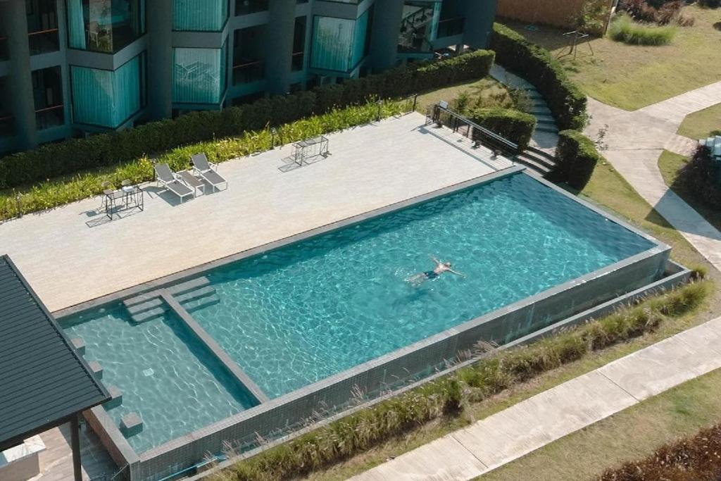 een uitzicht op een persoon die in een zwembad zwemt bij The Posh Khao Kho in Ban Nong Chaeng