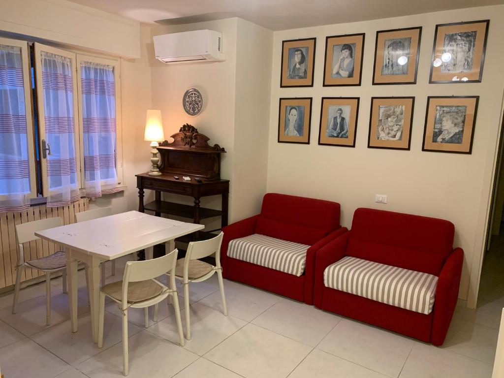 a living room with a red couch and a table at LucevanLeStelle - Full Comfort Quiet Apartment by the Promenade in Viareggio