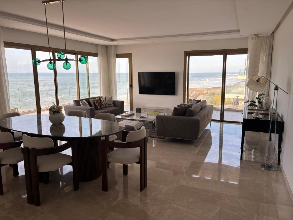 een woonkamer met een tafel en stoelen en een woonkamer bij Carrousel Atlantic View in Rabat