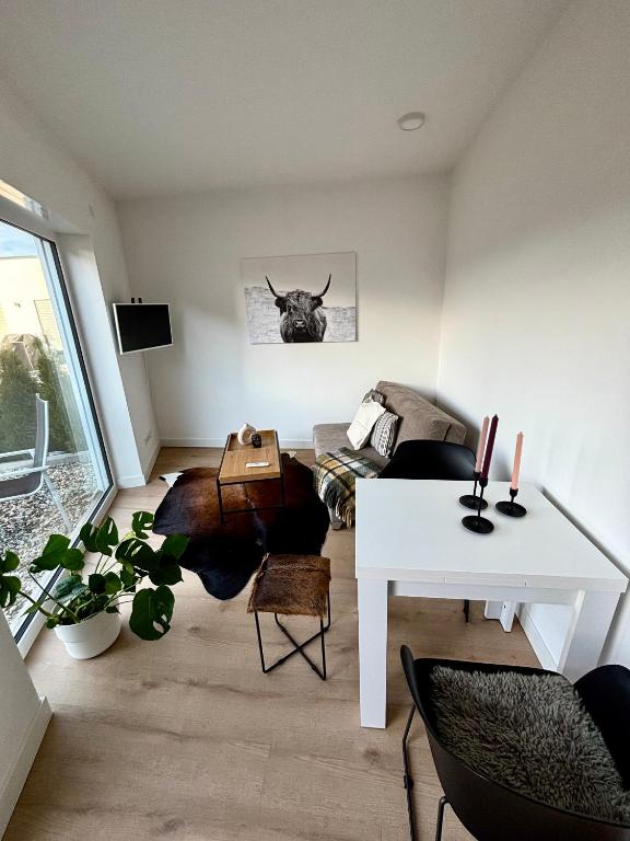 een woonkamer met een witte tafel en een stierenkop aan de muur bij Moderne Ferienwohnung nahe Bostalsee in Nohfelden