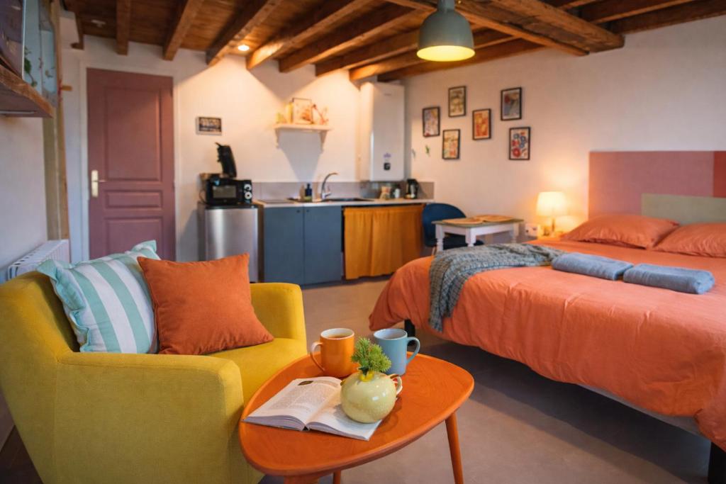 een slaapkamer met een bed, een bank en een tafel bij Studio Pop-25m2-Neuf et coloré - WiFi-Netflix in Bellême