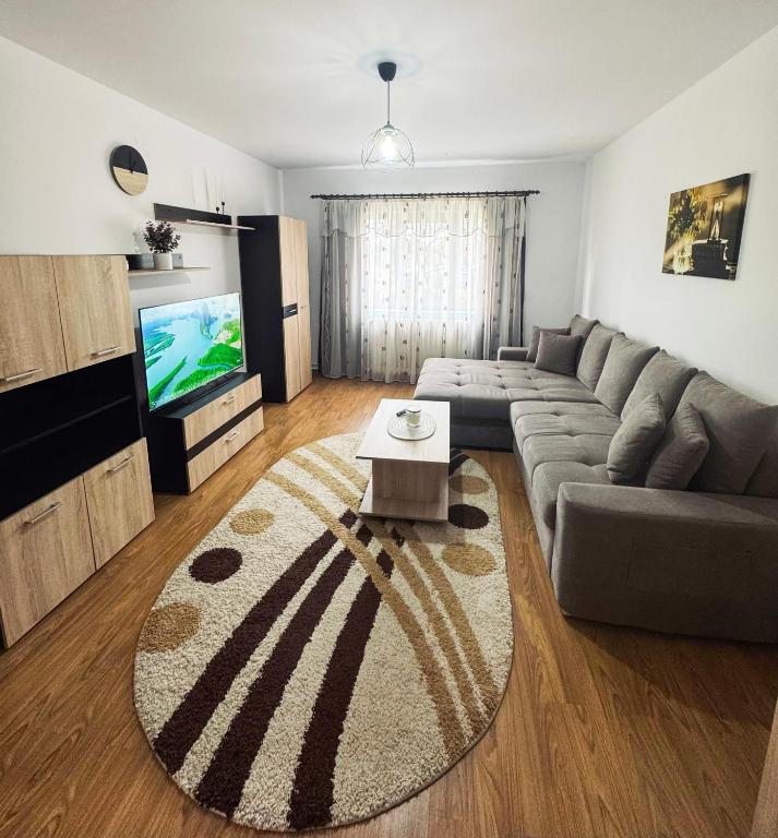 a living room with a couch and a tv at Edge Apartament in Cristuru Secuiesc