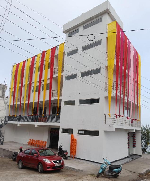 a red car parked in front of a building at Hotel HimNivasa in Tehri-Garhwāl