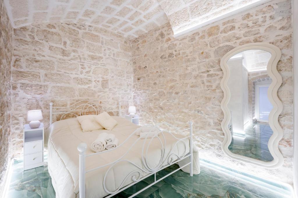 una camera da letto con un letto bianco e uno specchio di Stella Marina a Molfetta