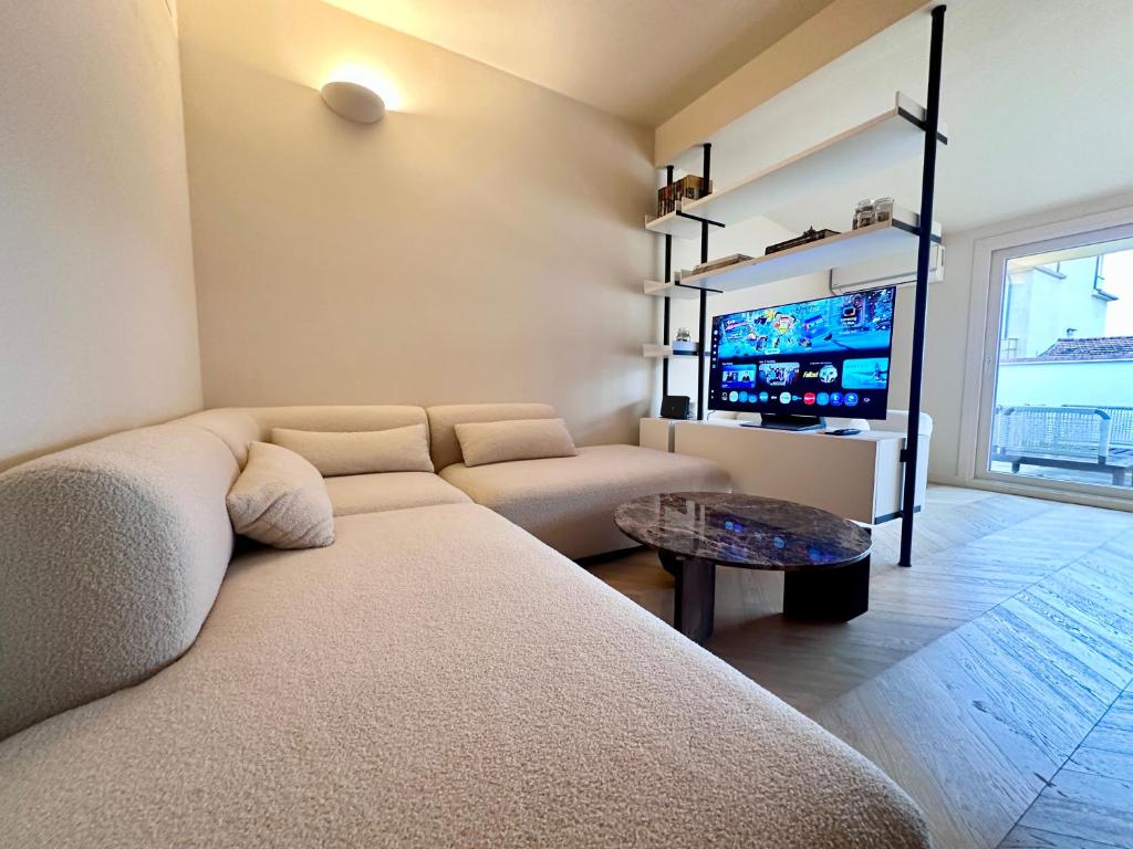 ein Wohnzimmer mit Sofa und Flachbildfernseher in der Unterkunft Front Beach Apartments - Attic in Viareggio