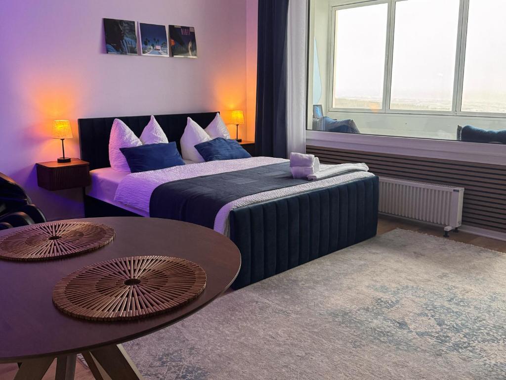 a hotel room with two beds and a table at CuxHeaven - modernes Studio-Apartment direkt am Meer mit Pool, Sauna und Massage in Cuxhaven