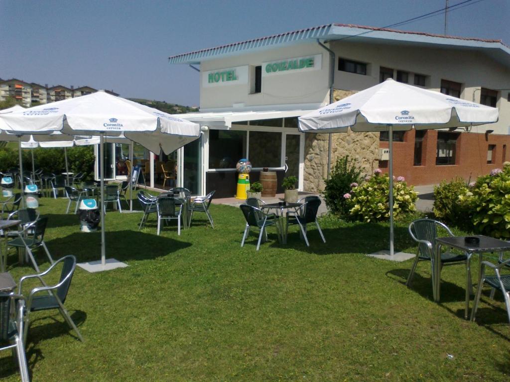 un grupo de mesas y sillas con sombrillas en Hotel Goizalde, en Sopelana